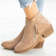 Stylish suede ankle boots with a wedge heel, featuring a zipper, perfect for modern women seeking comfort and fashion.
