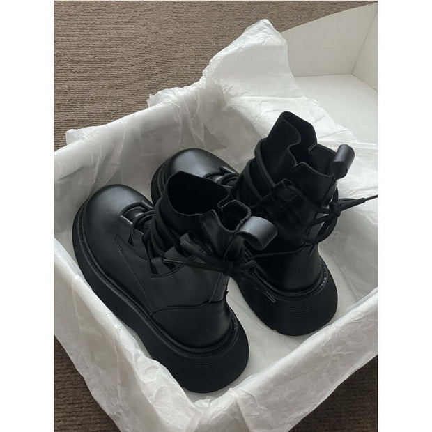 Black Martin boots with thick sole in a shoe box, showcasing a professional lace-up design for women.