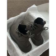 Brown Martin boots with thick sole and lace-up design in a shoebox, showcased for women's fashionable footwear.